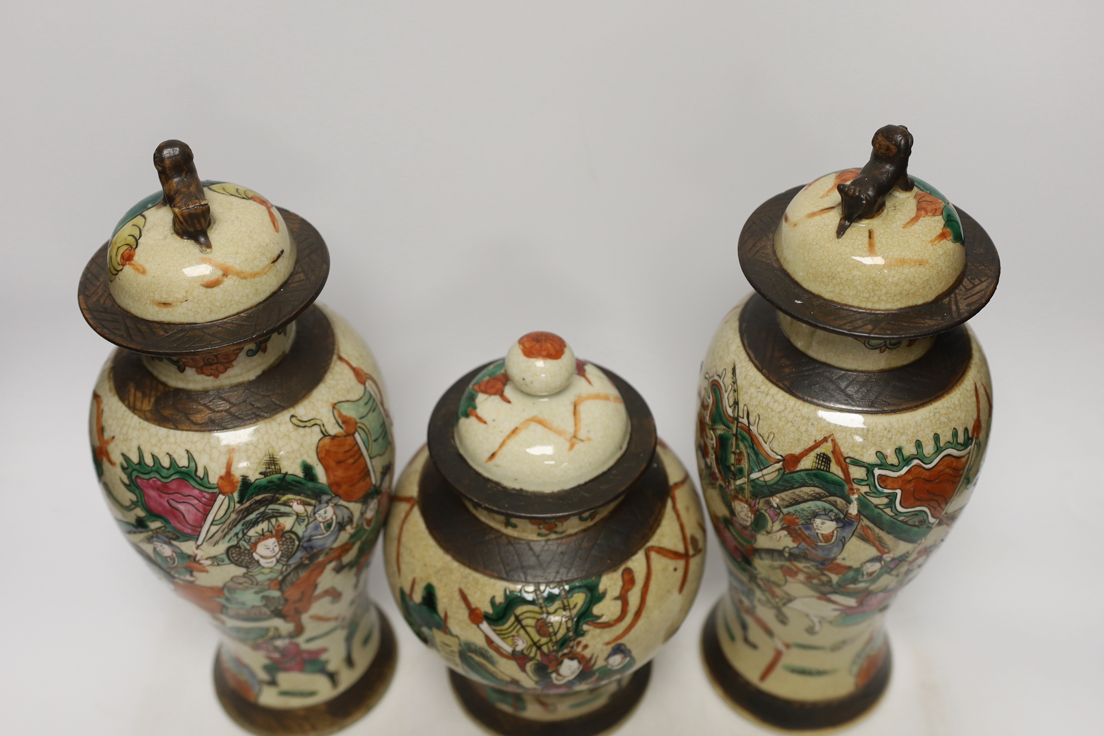 Three various Chinese crackleware famille rose jars and covers including a baluster example, largest 35cm high